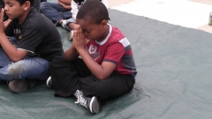 This photo of Derek was taken today near the end of the kids' meeting when we were praying for the children.